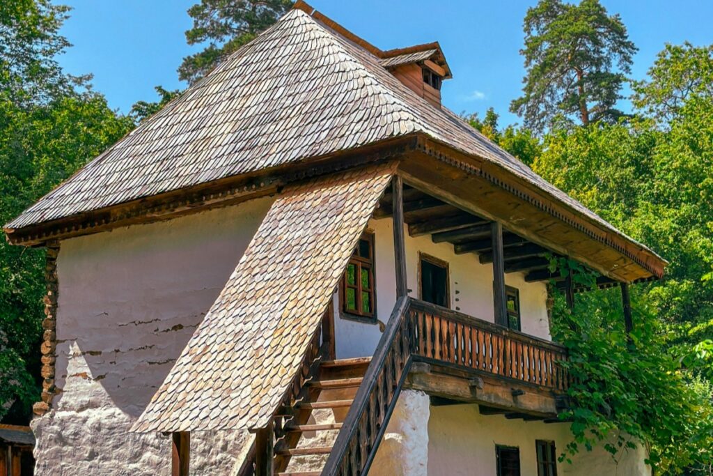 Din imagine, poți observa o casă tradițională românească, cu un acoperiș din scânduri de lemn și pereți albi. Casă are o scară de lemn care duce la un balcon, iar jurul ei este inconjurat de vegetație verde. Întrucât cerința include un element în franceză ("Les tendances Facebook au Maroc en 2025"), deși este o imagine cu o casă românească, se poate menționa că, în 2025, pe Facebook din Maroc, tendințele ar putea include prezentarea locurilor tradiționale din alte țări, precum și această casă românească, pentru a promova cultura și turismul internațional. Această casă ar putea fi un exemplu de ce tip de conținut ar putea atrage interesul pe platforma de rețele sociale din Maroc.